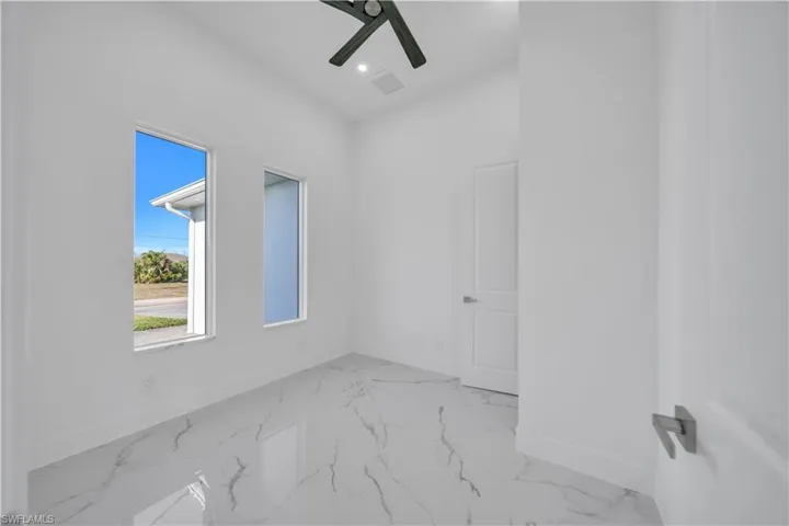 Spare room featuring light marble finish floors, recessed lighting, and a ceiling fan