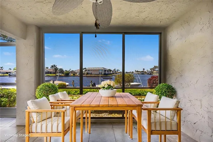 Screened lanai with view of intersecting canals.  VIRTUALLY STAGED