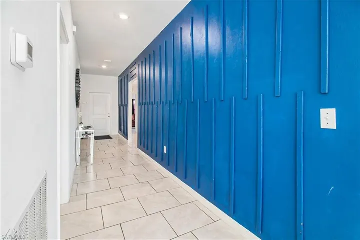 Hall featuring light tile patterned floors and recessed lighting