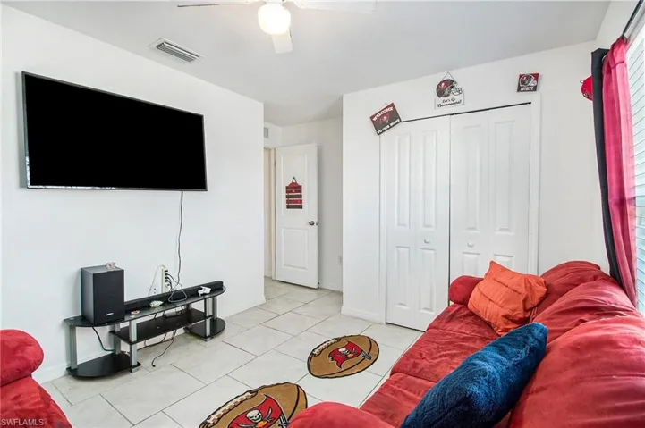 Living room featuring light tile patterned flooring and ceiling fan