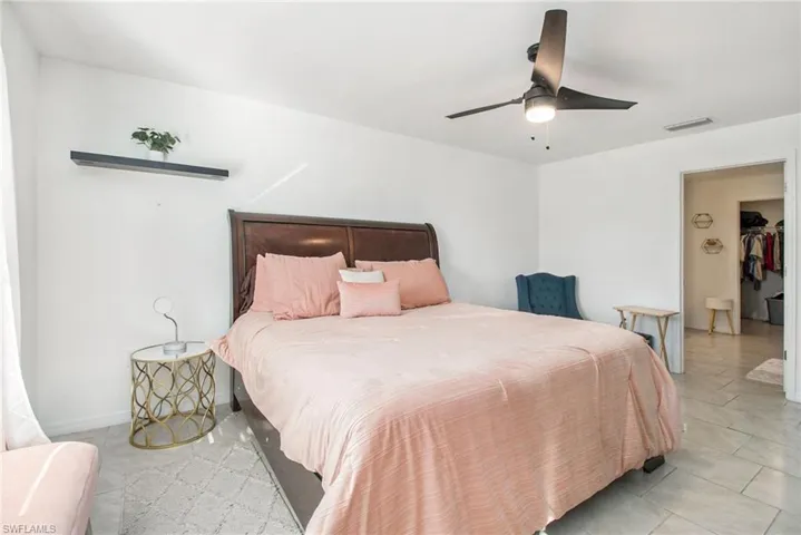 Bedroom with light tile patterned floors and ceiling fan