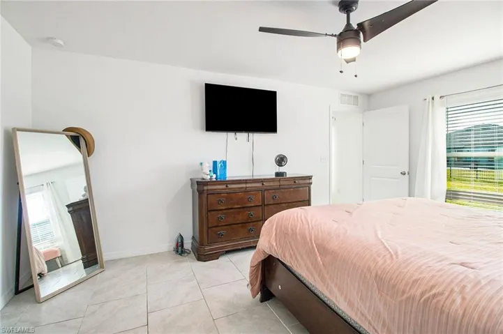 Bedroom with a ceiling fan and light tile patterned flooring
