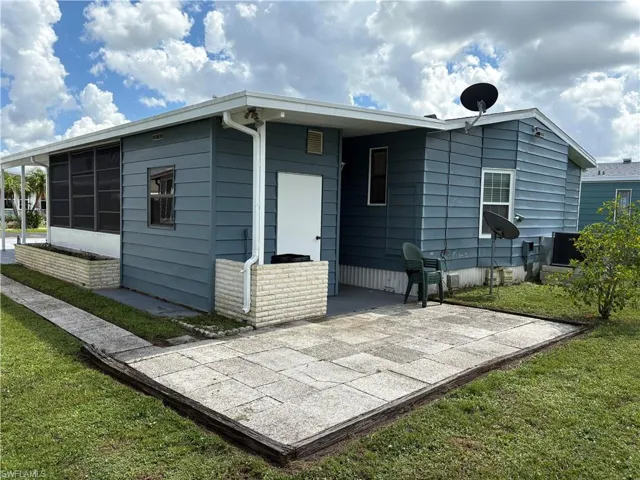 Back of house featuring a lawn and a patio