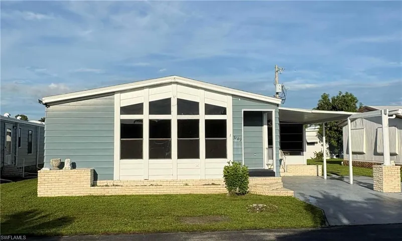 View of front of house with a front lawn and a carport