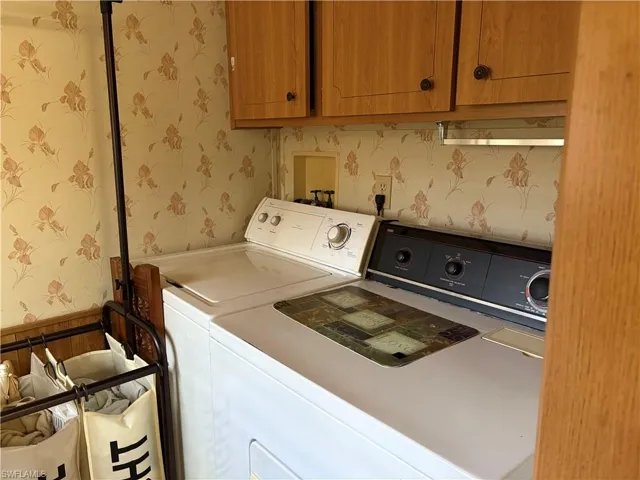 Laundry room with washer and clothes dryer and cabinets