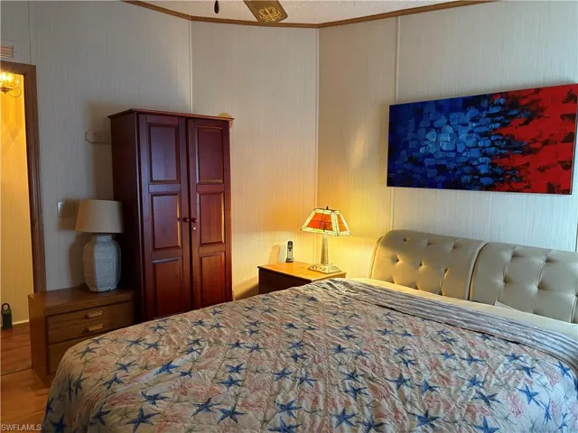 Bedroom featuring ceiling fan, hardwood / wood-style floors, and crown molding