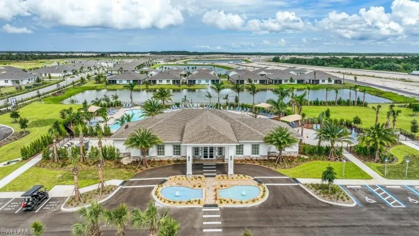 The property features a prominent clubhousebuilding with a paved entrance and twodecorative fountains, surrounded by lushlandscaping and palm trees