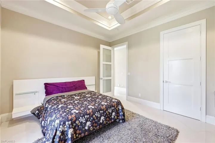 Guest bedroom with tray ceiling and custom doors