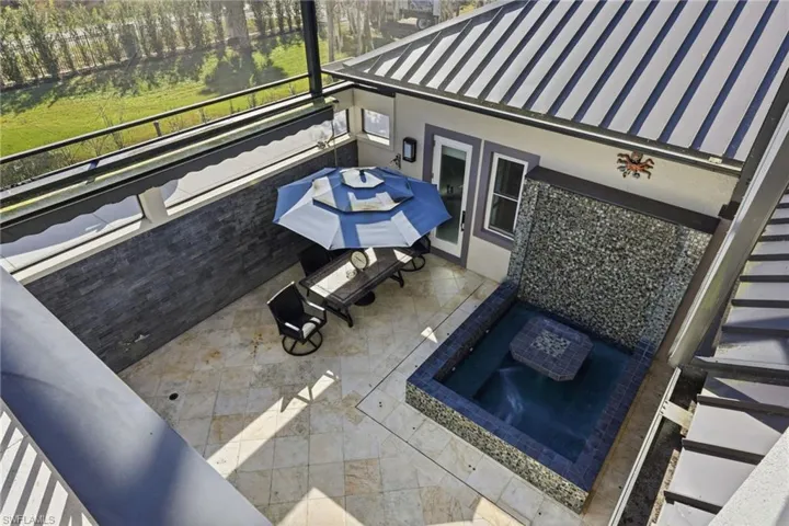 View from main bedroom balcony showing spa with table and waterfall