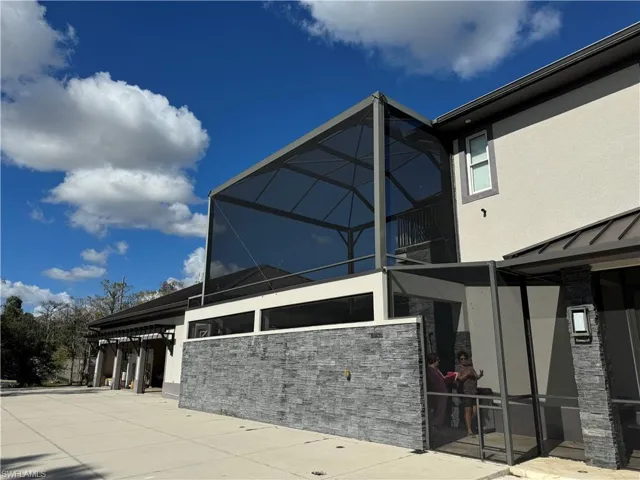 View of side of home featuring stucco siding, a lanai, and stone siding