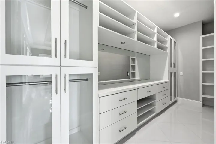 Main bedroom closet with built-ins and skylight