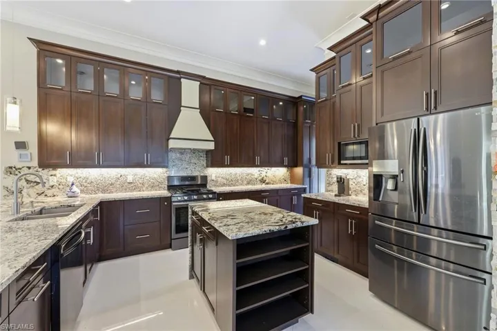 View of cabinets,island for prepping and fridge