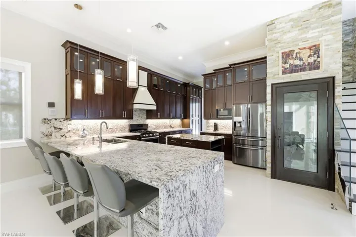 View of breakfast bar, wine cellar door, and fridge