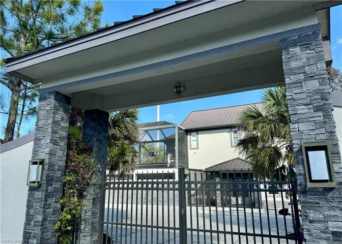 Gate featuring a lanai and a fenced front yard