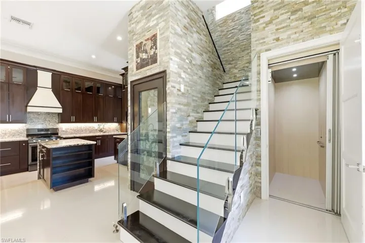 View of elevator, stairs, cellar entrance, and kitchen