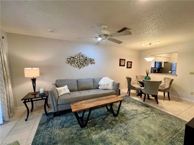 Tiled living room with a textured ceiling and ceiling fan