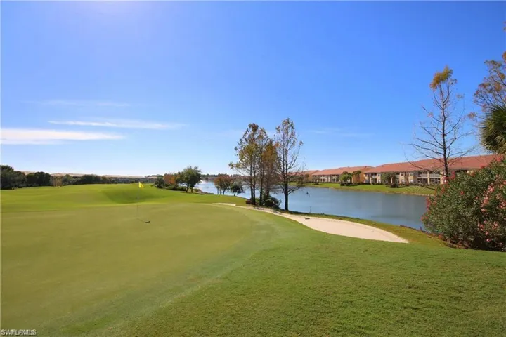 View of community featuring a water view, view of golf course, and a lawn