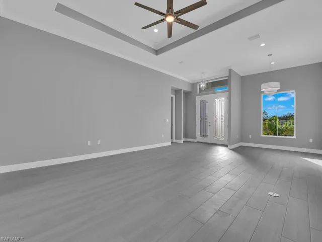 Spare room with ornamental molding, a ceiling fan, recessed lighting, wood finished floors, and a tray ceiling