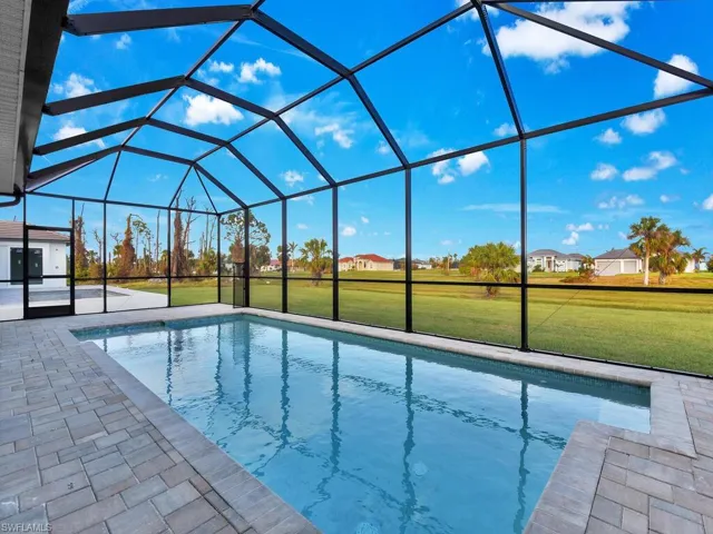 Swimming pool featuring a yard, a patio area, and a lanai