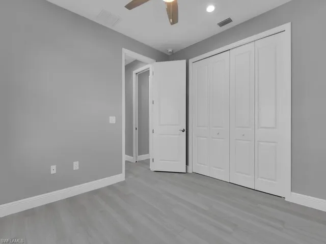 Unfurnished bedroom with wood finished floors, a closet, ceiling fan, and recessed lighting