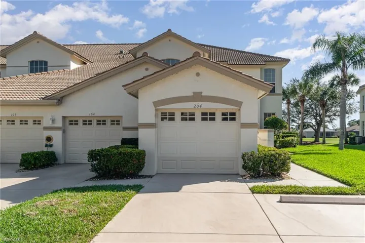 View of front of house with driveway, a front yard, an attached garage, and stucco siding