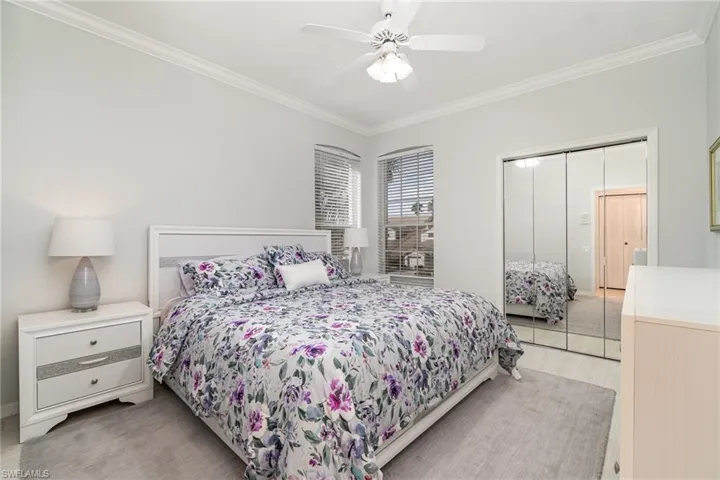 Guest bedroom with ceiling fan and crown molding
