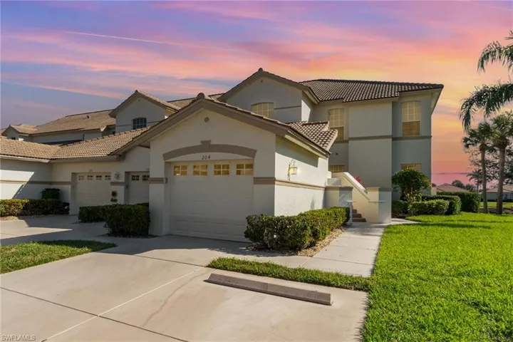 View of front facade with a garage, concrete driveway, stucco siding, a tiled roof, and a front yard