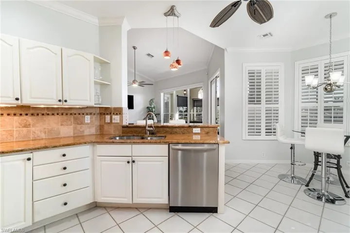 Kitchen featuring ceiling fan, stainless steel dishwasher, and crown molding