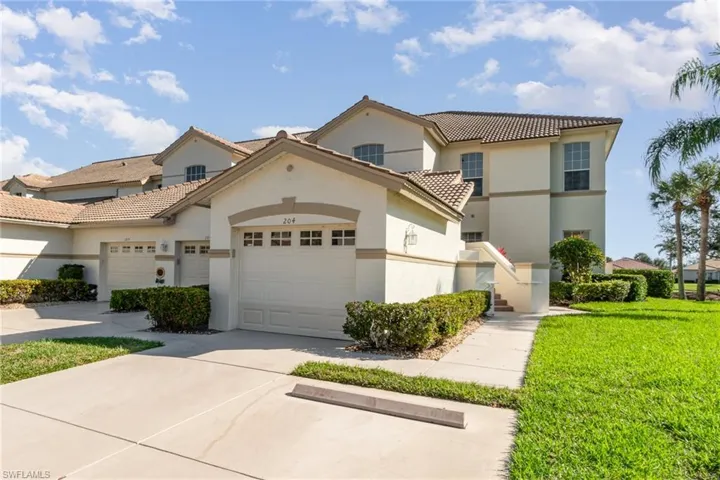 View of front of property with a tile roof, stucco siding, concrete driveway, an attached garage, and a front yard