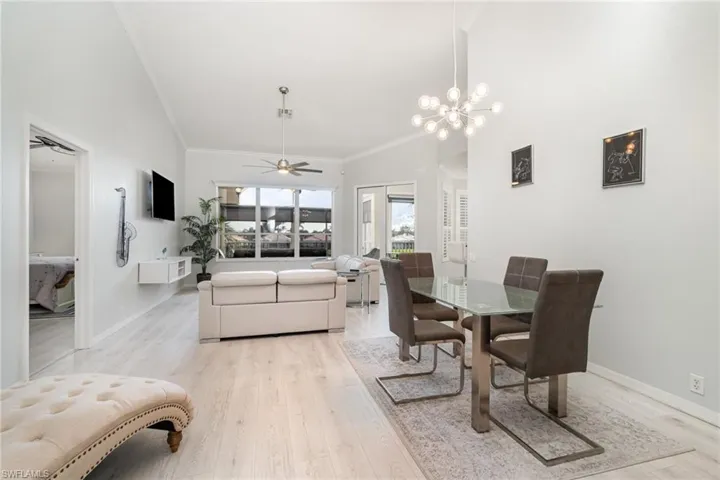 Dining room with crown molding, and vaulted ceilings and light wood-style floors