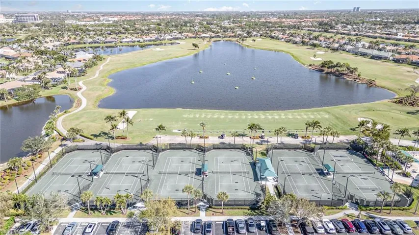 Bird's eye view with a water view and tennis courts