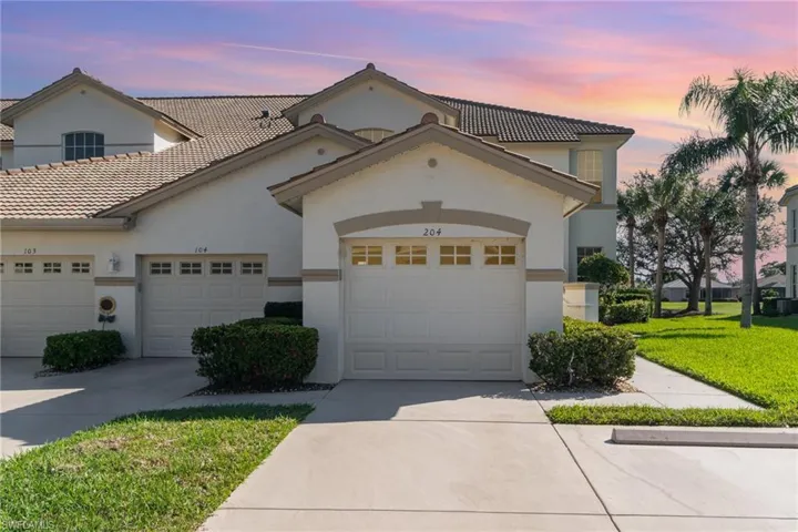 View of front of home featuring an attached garage, a front lawn, concrete driveway, and stucco siding