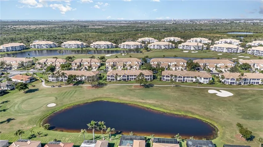 Bird's eye view of the rear of the property featuring a water and golf course view