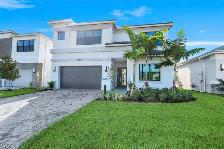 View of front facade featuring a front yard and a 2 car garage