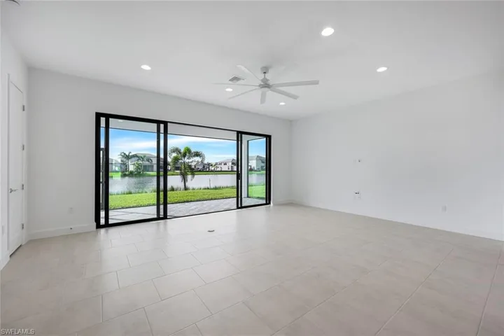 Living room featuring ceiling fan and a water view