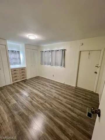 Unfurnished bedroom featuring a textured ceiling, wood finished floors, and visible vents