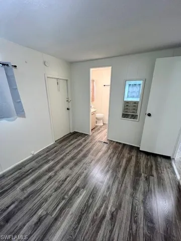 Empty room featuring wood finished floors and visible vents