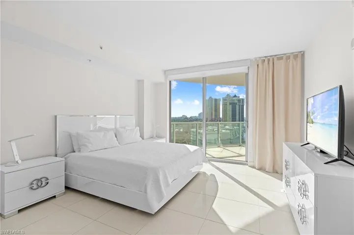 Bedroom featuring expansive windows, access to outside, and light tile patterned floors