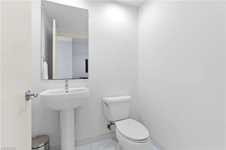 Half bathroom with baseboards and tile patterned flooring
