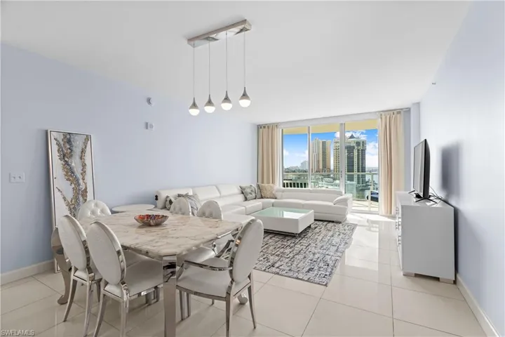 Dining area featuring a wall of windows and light tile patterned floors