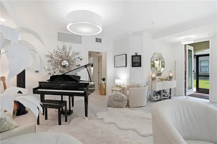 Open living area featuring light-toned flooring, white walls, and a contemporary ceiling light fixture