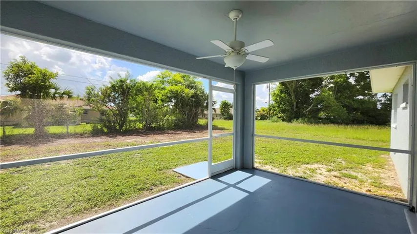 Unfurnished sunroom featuring ceiling fan