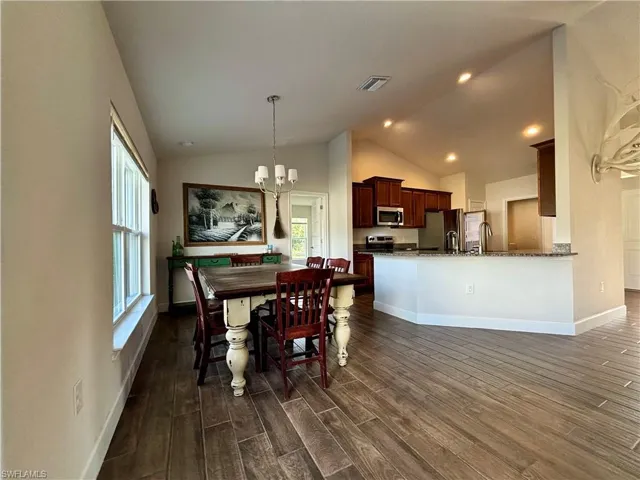 Dining room featuring an inviting chandelier, dark wood-style floors, baseboards, and visible vents