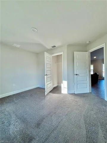 Bedroom # 2 with baseboards, carpet flooring, and closets