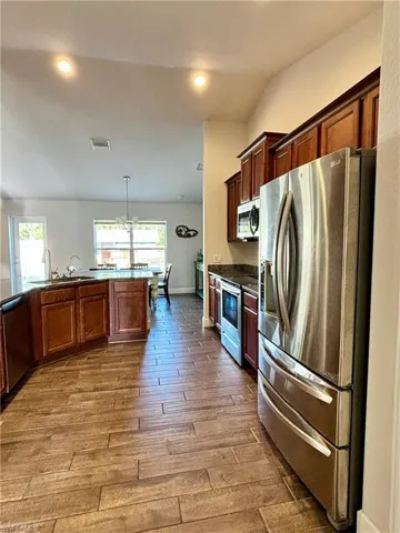 Kitchen featuring a healthy amount of sunlight, a sink, visible vents, appliances with stainless steel finishes, and wood finish tile  floors