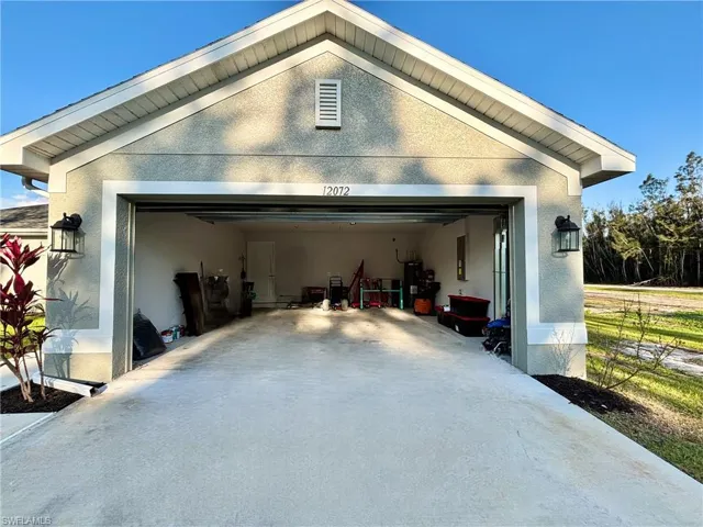 Garage featuring concrete driveway