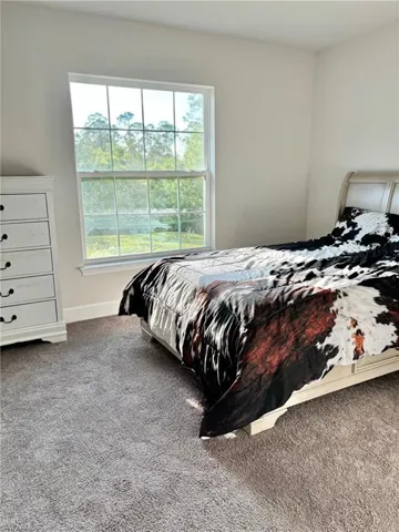 Bedroom # 4 featuring carpet floors and baseboards