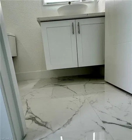 Bathroom view of vanity and a textured wall