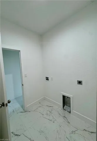 Laundry room with light marble finish floors, hookup for a washing machine, and hookup for an electric dryer
