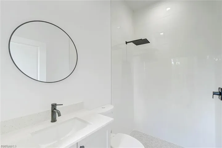 Bathroom with vanity and tiled shower